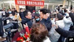 In this image taken from video, Li Jingwei, right, is reunited with his mother, center, and other relatives in Lankao in central China's Henan Province, Jan. 1, 2022. 
