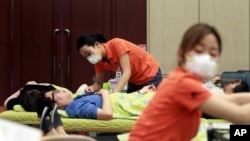 FILE - Nurses wear masks as a precaution against the MERS (Middle East Respiratory Syndrome) as they take blood donations from officials at Dongdaemun District Office in Seoul, South Korea, Thursday, June 18, 2015. 