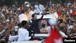 Myanmar pro-democracy leader Aung San Suu Kyi greets supporters while arriving at a campaign rally ahead of upcoming general elections in Yangon, Nov.1, 2015. 