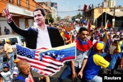 Opposition supporters carrying a cardboard cutout of Venezuelan opposition leader Juan Guaido take part in a rally against Venezuelan President Nicolas Maduro's government in Maracaibo, Venezuela, Feb. 12, 2019.