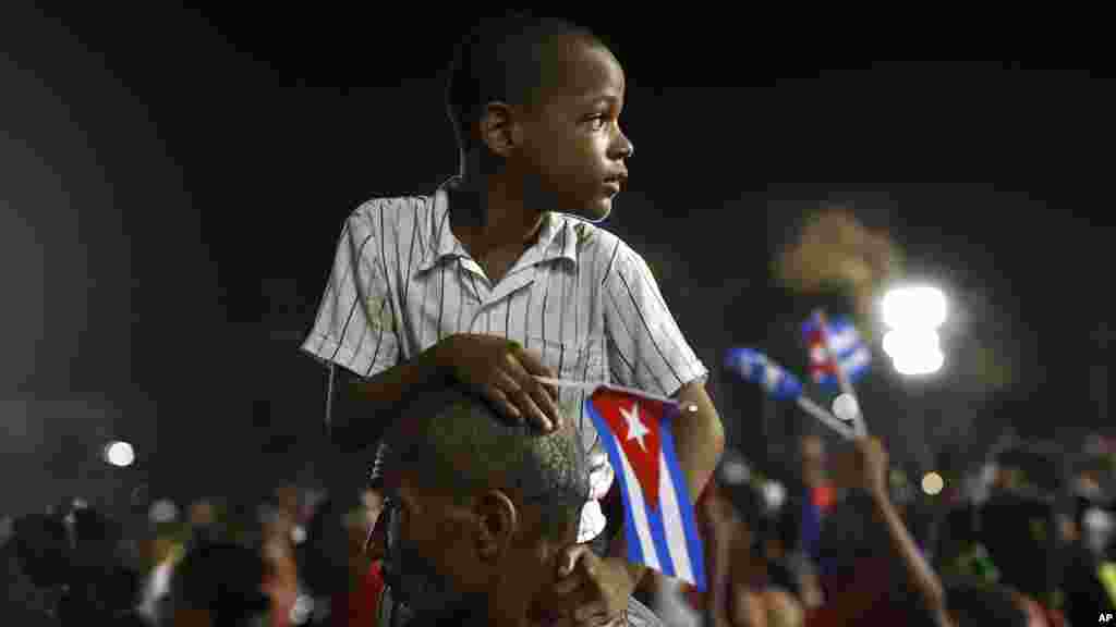 Un enfant assis sur les épaules d&#39;un homme pour avoir une meilleure vue des funérailles de Fidel Castro à Santiago, le 3 décembre 2016.