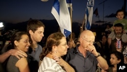 Noam and Aviv Schalit, right, Yoel Schalit and Yaara Winkler, parents and brother of captured Israeli soldier Gilad Schalit are welcomed by family and friends to their home in Mitzpe Hila, northern Israel, October 12, 2011.
