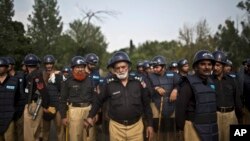 Pakistani police officers stand guard near the Parliament building after tens of thousands of protesters entered Islamabad's high-security Red Zone the night before, five days after arriving in the capital from the eastern city of Lahore in convoys, in Is