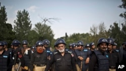 Pakistani police officers stand guard near the Parliament building after tens of thousands of protesters entered Islamabad's high-security Red Zone the night before, five days after arriving in the capital from the eastern city of Lahore in convoys, in Is