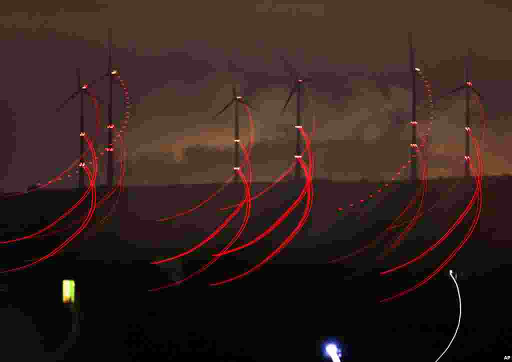 Red warning lights for aircrafts fixed at wind power plants shine in the night in Kirchheimbolanden, Germany.