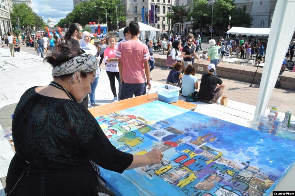 Syrian artist Etab Hreib works on a live mural and calligraphy demonstration in the Syria Fest cultural tent in Washington, Sept. 3, 2017. (Photo courtesy of Rabah Seba)