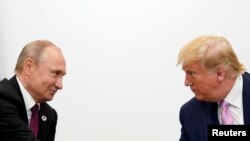 El presidente de EE.UU.,Donald Trump (derecha) y el presidente de Rusia, Vladimir Putin vistos durante una reunión bilateral al margen de la cumbre del G-20 en Osaka, Japón, el 28 de junio de 2019.