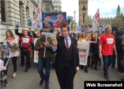 Adam Garrie, who has appeared on Russian state media outlets like RT, leads a 2017 Immortal Regiment march in London with pictures of "Motorola" and "Givi," who fought in Donbas in 2014-2015.