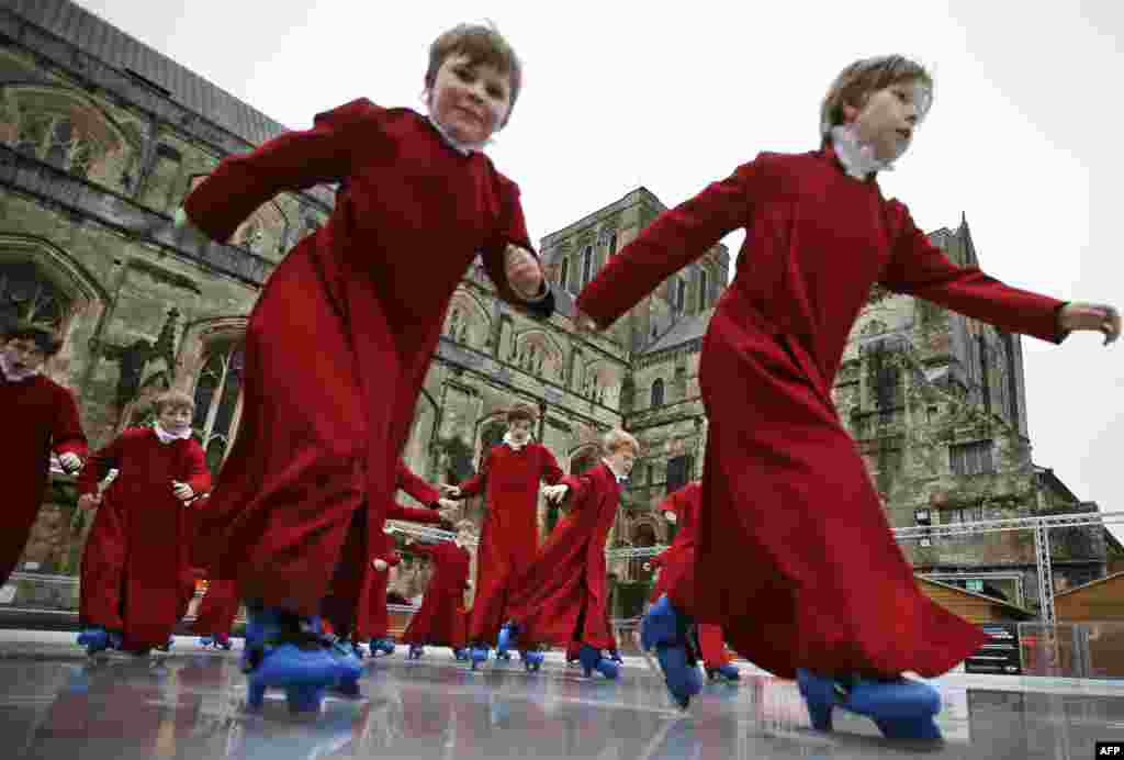 Winchester Cathedral choristers speed across the ice during an early morning skate on the ice rink outside Winchester Cathedral, southern England.