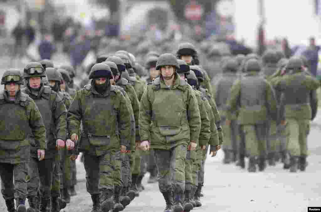 Uniformed men, believed to be Russian servicemen, march outside a Ukrainian military base in the village of Perevalnoye, outside Simferopol, March 5, 2014. 