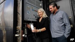 The Skysource/Skywater Alliance co-founders David Hertz, right, and his wife Laura Doss-Hertz demonstrate their invention Wednesday, Oct. 24, 2018, in Los Angeles. (AP Photo/Marcio Jose Sanchez)