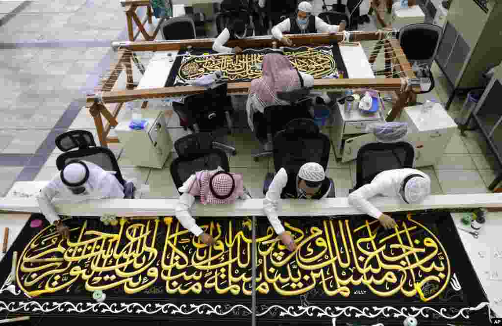 Saudi workers embroider Islamic calligraphy at the Kiswa factory in Mecca, Saudi Arabia, during the final stages in the preparation of a drape, or Kiswa, that covers the Kaaba, a cube-shaped structure at the heart the Grand Mosque.
