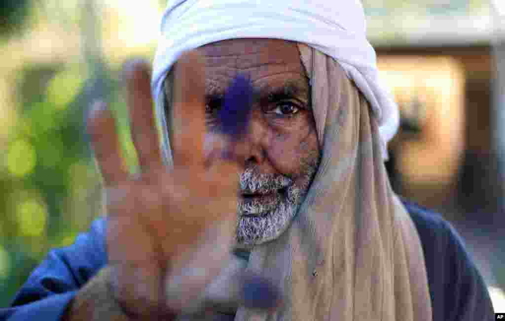 An elderly Egyptian man shows his inked finger after casting his vote on the second round of a referendum on a disputed constitution drafted by Islamist supporters of President Mohammed Morsi in Fayoum Saturday, Dec. 22.