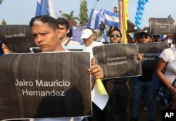 Marchers hold signs with the names of those killed during recent protests, during a march for "Peace and Justice" called by the Catholic Church, in Managua, Nicaragua, April 28, 2018.