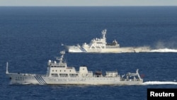 An aerial photo from a Kyodo News aircraft shows the Chinese marine surveillance ship Haijian No. 51 (front) cruising as a Japan Coast Guard ship sails near the disputed islands, called Senkaku in Japan and Diaoyu in China, in the East China Sea, Septembe