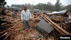 A man stands on the rubbles of his home after bulldozers demolished dozens of houses to make way for a new road in the Kibera slum in Nairobi, Kenya, July 23, 2018. 