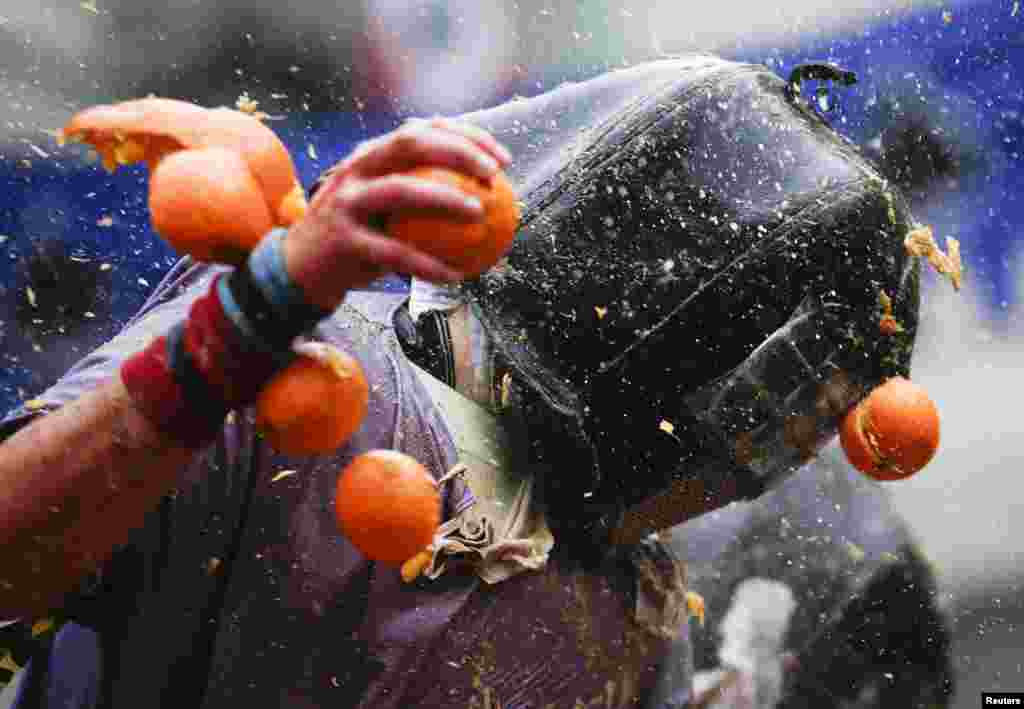 A member of a rival team is hit by an orange during an annual carnival battle in the northern Italian town of Ivrea.