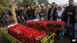 Dolientes entierran a dos víctimas del ataque a la escuela en Peshawar, Pakistán.