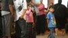 Children stand in line with some of the thousands of young immigrants at Chicago's Navy Pier on Aug. 15, 2012