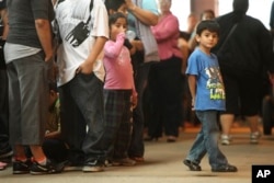 FILE - Children stand in line with some of the thousands of young immigrants at Chicago's Navy Pier on Aug. 15, 2012.