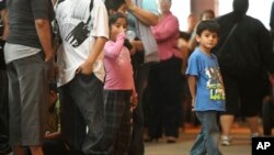 Children stand in line with some of the thousands of young immigrants at Chicago's Navy Pier on Aug. 15, 2012