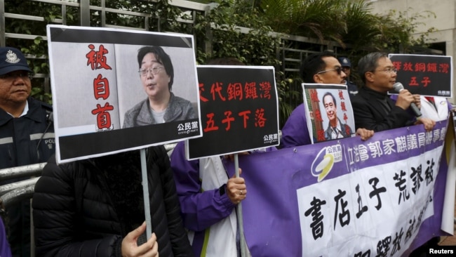 資料照：香港抗議者在北京駐香港機構中聯辦前手舉銅鑼灣書店失蹤老闆桂民海的照片。 （2016年1月19日）