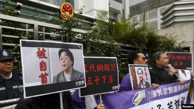 资料照：香港抗议者在北京驻香港机构中联办前手举铜锣湾书店失踪老板桂民海的照片。 （2016年1月19日）