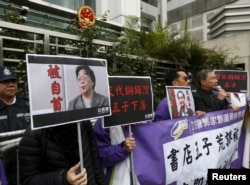 資料照：香港抗議者在北京駐香港機構中聯辦前手舉銅鑼灣書店失踪老闆桂民海的照片。 （2016年1月19日）