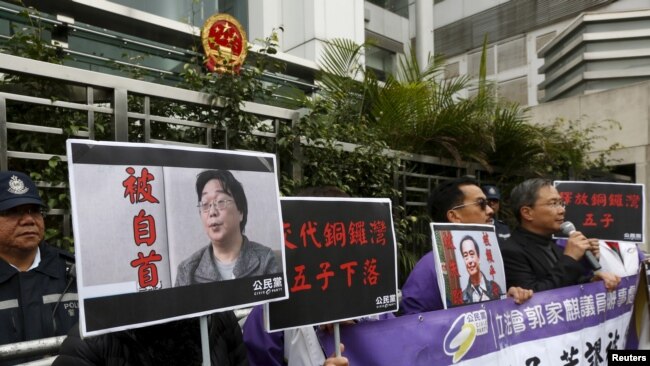 资料照：香港抗议者在北京驻香港机构中联办前手举铜锣湾书店失踪老板桂民海的照片。 （2016年1月19日）