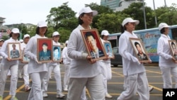 In this 2012 file photo, members of Falun Gong in Taiwan hold portraits of victims during a protest against Chinese government's policy against its members in China.