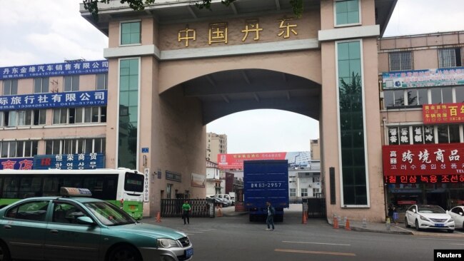 一輛掛朝鮮牌照的卡車開進中國遼寧丹東市的一個院落，院子里停著裝滿貨物的卡車準備通過友誼橋前往朝鮮。（2018年6月12日）