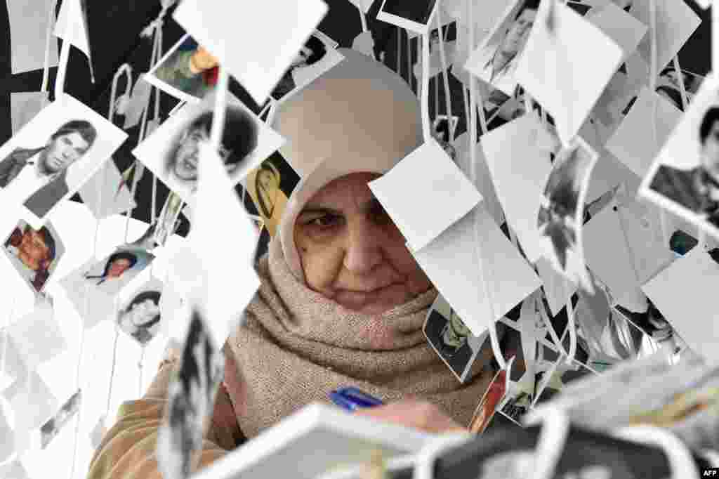 A woman writes a note in the golden book inside the memorial of victims, in front of the International Criminal Tribunal for the former Yugoslavia (ICTY) in The Hague, prior to the verdict in the genocide trial of former Bosnian Serbian commander Ratko Mladic. United Nations judges in sentenced Mladic, dubbed the &quot;Butcher of Bosnia&quot;, to life in jail for crimes committed during the 1992-1995 war that killed 100,000 people as ethnic rivalries tore apart Yugoslavia.