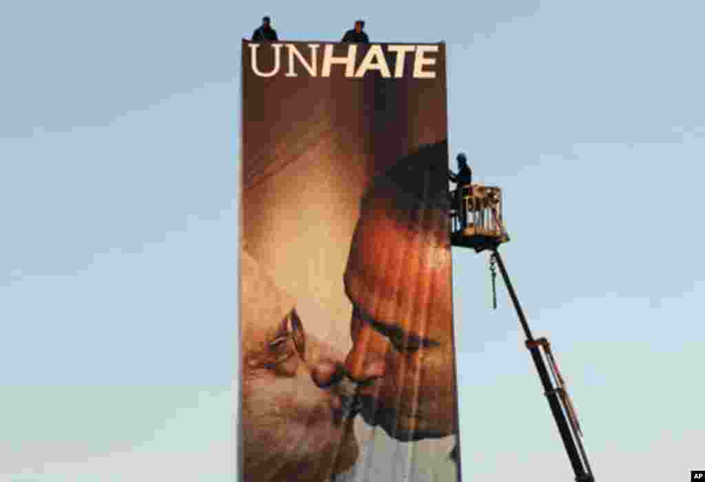 Workers install a Benetton billboard advertisement showing a composite image of Israeli Prime Minister Benjamin Netanyahu (R) kissing Palestinian President Mahmoud Abbas in Tel Aviv November 28, 2011. The image, part of a series of pictures of world leade