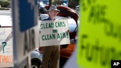 FILE - Paul Gipe protests before the first of three public hearings on the Trump administration's proposal to roll back car-mileage standards in a region with some of the nation's worst air pollution, in Fresno, Calif., Sept. 24, 2018. 