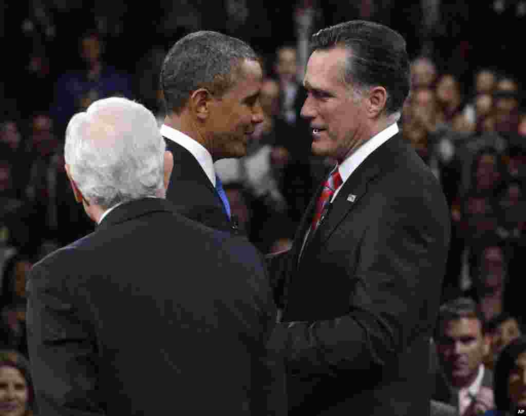 Le pr&eacute;sident Obama et son adversaire r&eacute;publicain Mitt Romney se saluant sous le regard du journaliste Bob Schieffer 