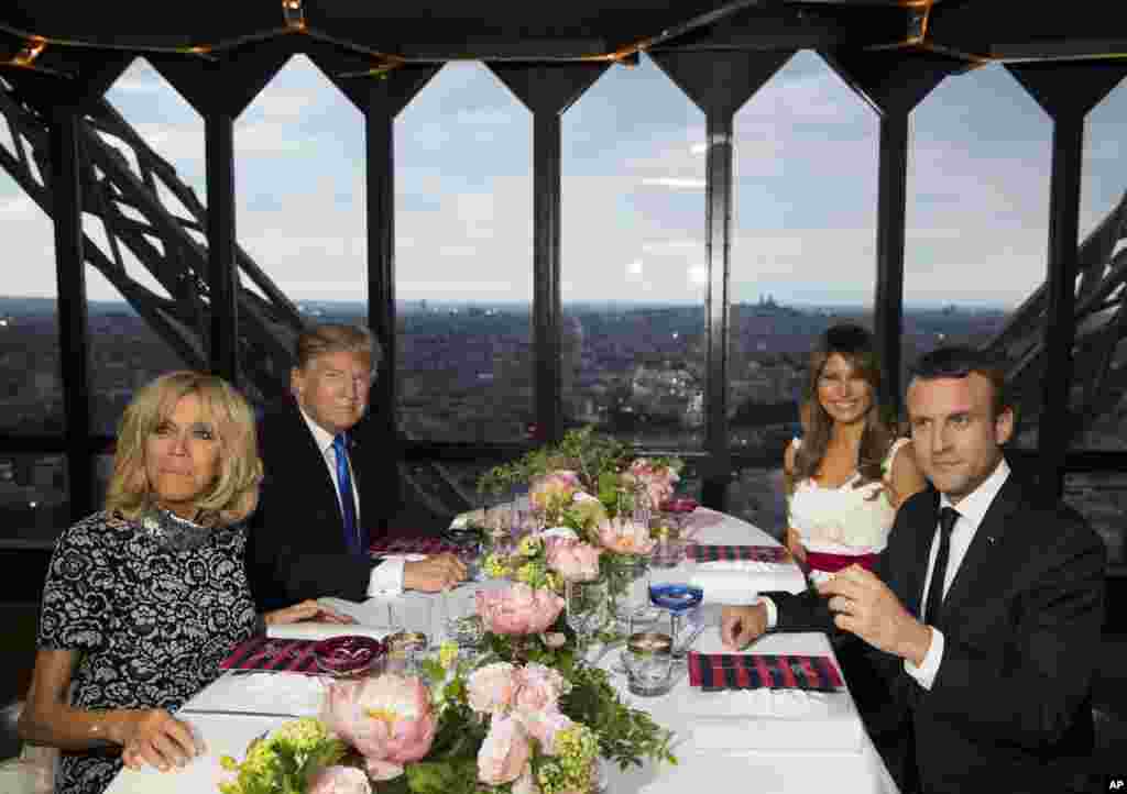 President Donald Trump, first lady Melania Trump, French President Emmanuel Macron, his wife Brigitte Macron, sit for dinner at the Jules Verne Restaurant on the Eiffel Tower in Paris.