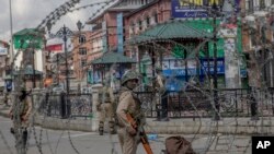 FILE - Indian Paramilitary soldiers are seen through barbed wire in Srinagar, Indian-controlled Kashmir, May 19, 2018.