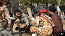 In this photo provided by the Iranian Students' News Agency, ISNA, Iranian armed forces members and civilians take cover in a shooting attack during a military parade marking the 38th anniversary of Iraq's 1980 invasion of Iran, in the southwestern city of Ahvaz, Iran, Sept. 22, 2018. 