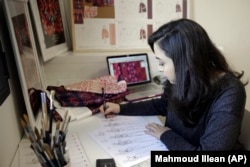 In this Tuesday, January 29, 2019 photo, designer Natalie Tahhan draws a traditional Palestinian thobe at her studio in east Jerusalem.