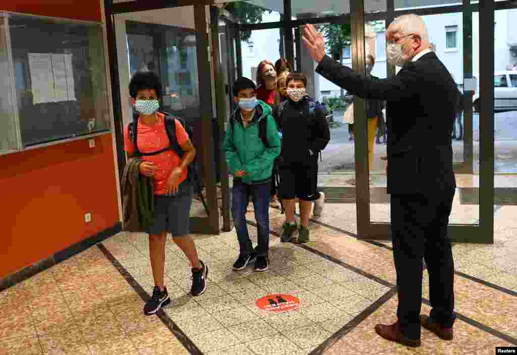 Director Juergen Scheuermann welcomes students as schools re-open after summer vacation and the COVID-19 lockdown, at the Karl-Rehbein high school in Hanau, Germany.