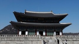 A visitor wearing a face mask poses for a photo at the Gyeongbok Palace, one of South Korea's well-known landmarks, in Seoul, South Korea, Monday, March 16, 2020.