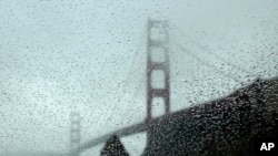 Rain drops bead on a car window below the Golden Gate Bridge, Jan. 5, 2016, in Sausalito, Calif. El Nino storms lined up in the Pacific, promising to drench parts of the West for more than two weeks.
