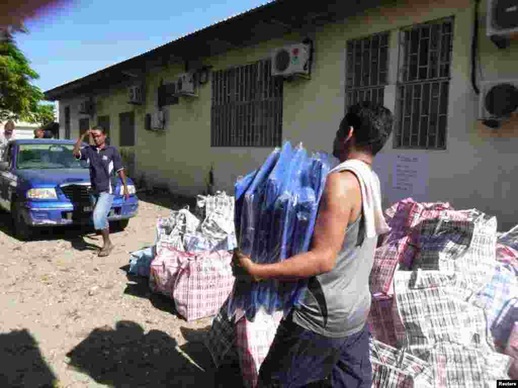 A worker carries aid as he prepares to load a truck before heading to earthquake and tsunami affected areas in Honiara, Solomon Islands, Feb. 7, 2013. (World Vision)