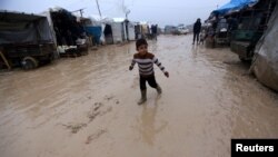 An internally displaced Syrian boy walks through the Bab Al-Salam refugee camp, near the Syrian-Turkish border, northern Aleppo province, Syria, Dec. 26, 2016.