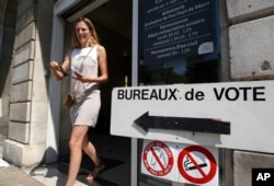 A woman leaves a polling station in the first round of parliamentary elections in Pau, southwestern France, June 11, 2017.