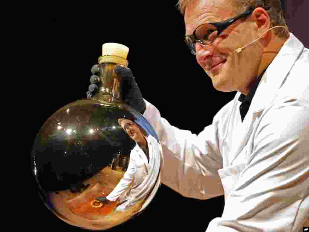 A chemist is reflected in a beaker after mixing chemicals that gave the beaker a reflective coating during a demonstration at the 21st annual Ig Nobel prize ceremony at Harvard University in Cambridge, Massachusetts September 29, 2011. The annual prizes, 
