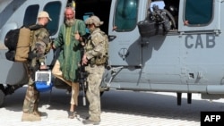 Dutch former hostage Sjaak Rijke (C) gestures next to two soldiers of the French special forces as he disembarks from a Caracal helicopter after being released, at a French Military airbase in Mali, April 6, 2015. (ECPAD handout photo)