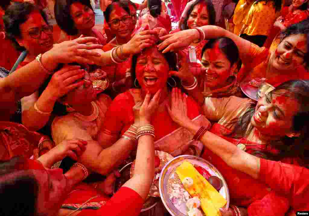 A Hindu woman reacts as &quot;Sindhur,&quot; or vermillion powder, is applied to her face after worshipping an idol of the Hindu goddess Durga on the last day of the Durga Puja festival in Chandigarh, India.