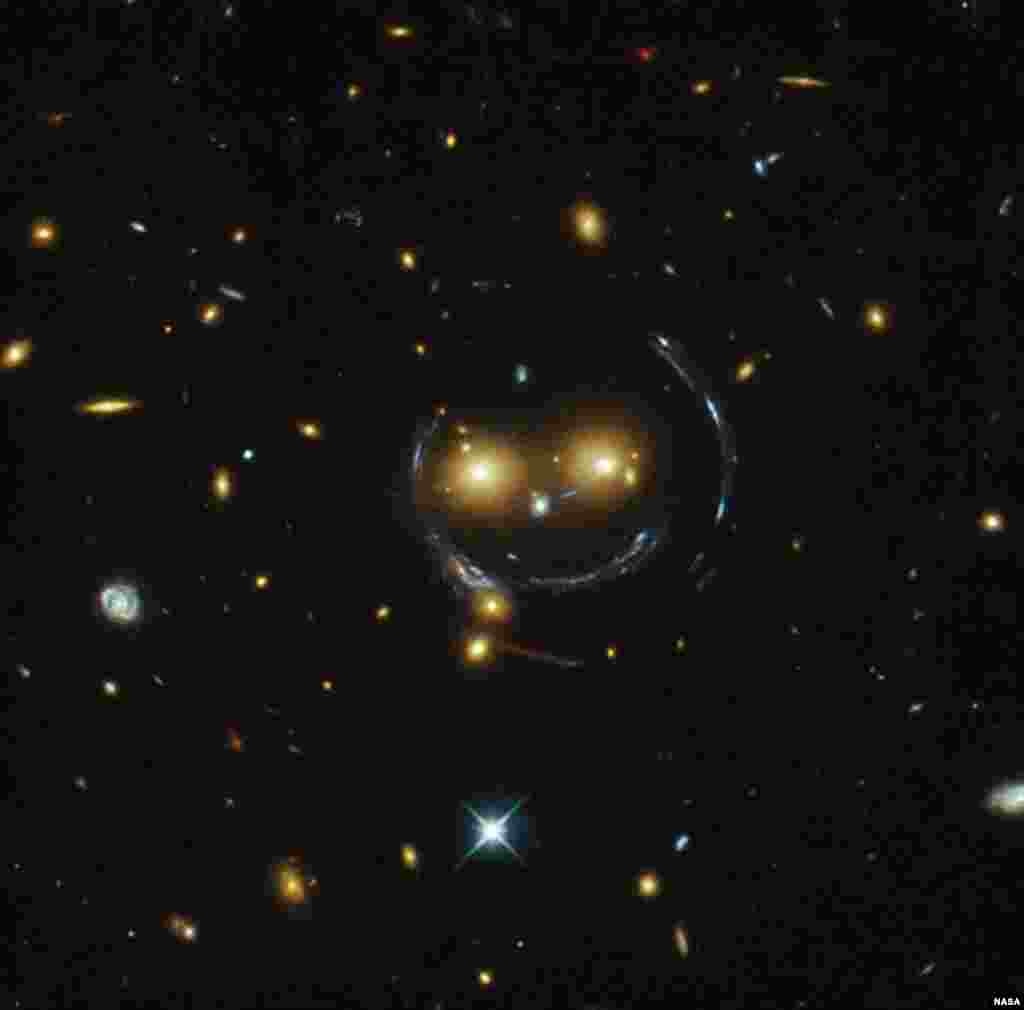 Foto dari teleskop Hubble NASA menunjukkan kelompok galaksi SDSS J1038+4849 yang terlihat seperti wajah yang tersenyum.