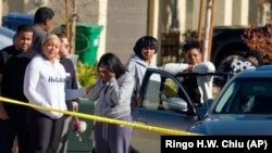 Para tetangga yang tinggal di dekat lokasi penembakan di Lancaster, California, AS, di mana empat orang anak-anak dan nenek mereka ditemukan tewas tertembak, tampak bereaksi di dekat lokasi kejadian pada 29 November 2021. (Foto: AP/Ringo H. W. Chiu)